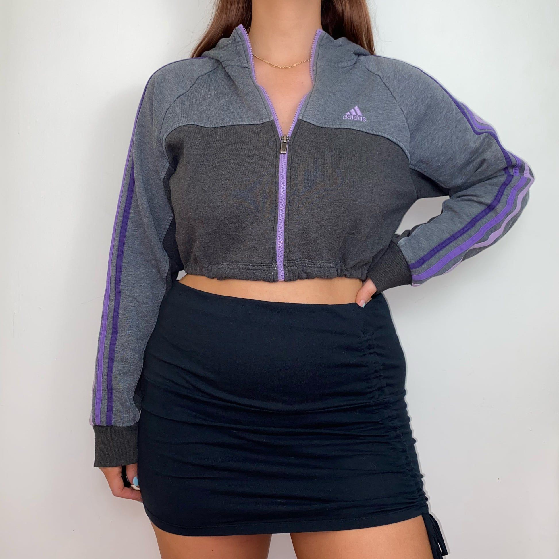 grey and purple 1/4 zip cropped hoodie with purple adidas logo shown on a model wearing a black skirt