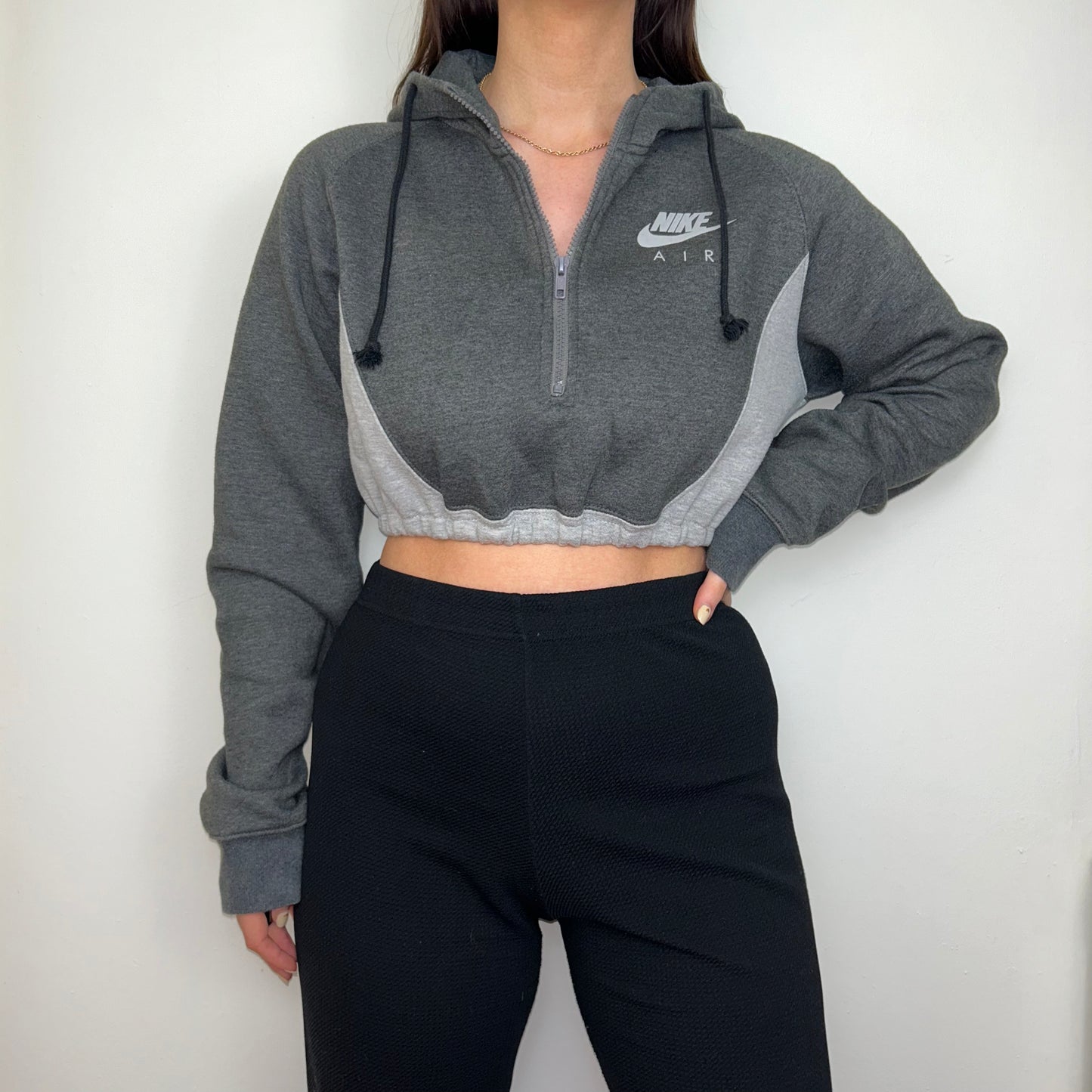 grey 1/4 zip cropped hoodie with grey nike air logo shown on a model wearing black trousers