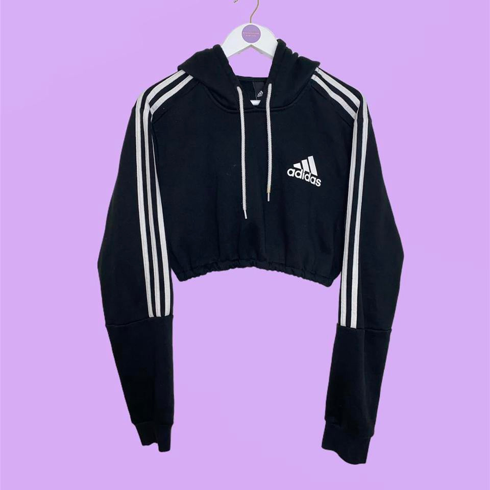 black cropped hoodie with white adidas logo shown on a lilac background