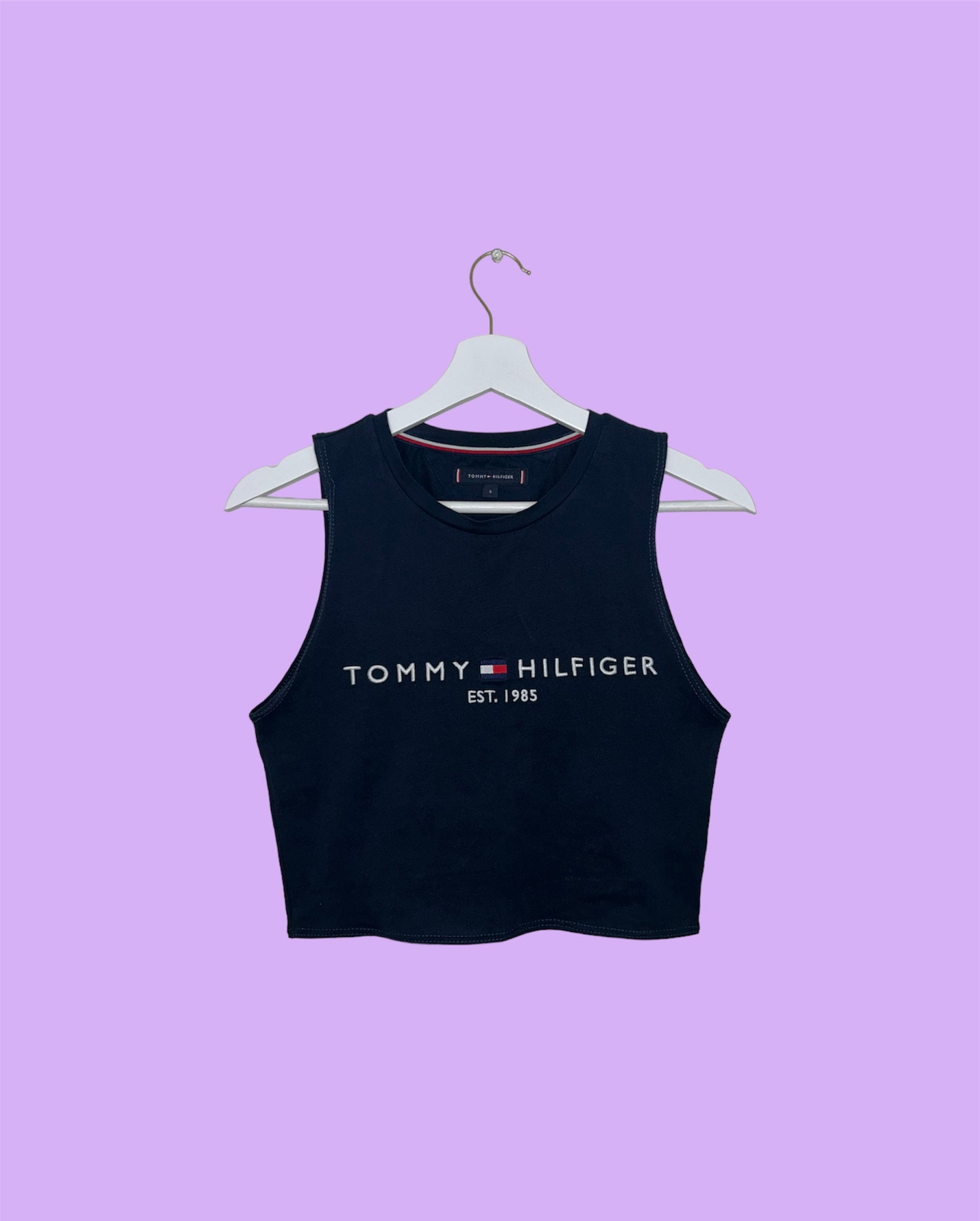 navy sleeveless crop top with white tommy hilfiger logo shown on a lilac background