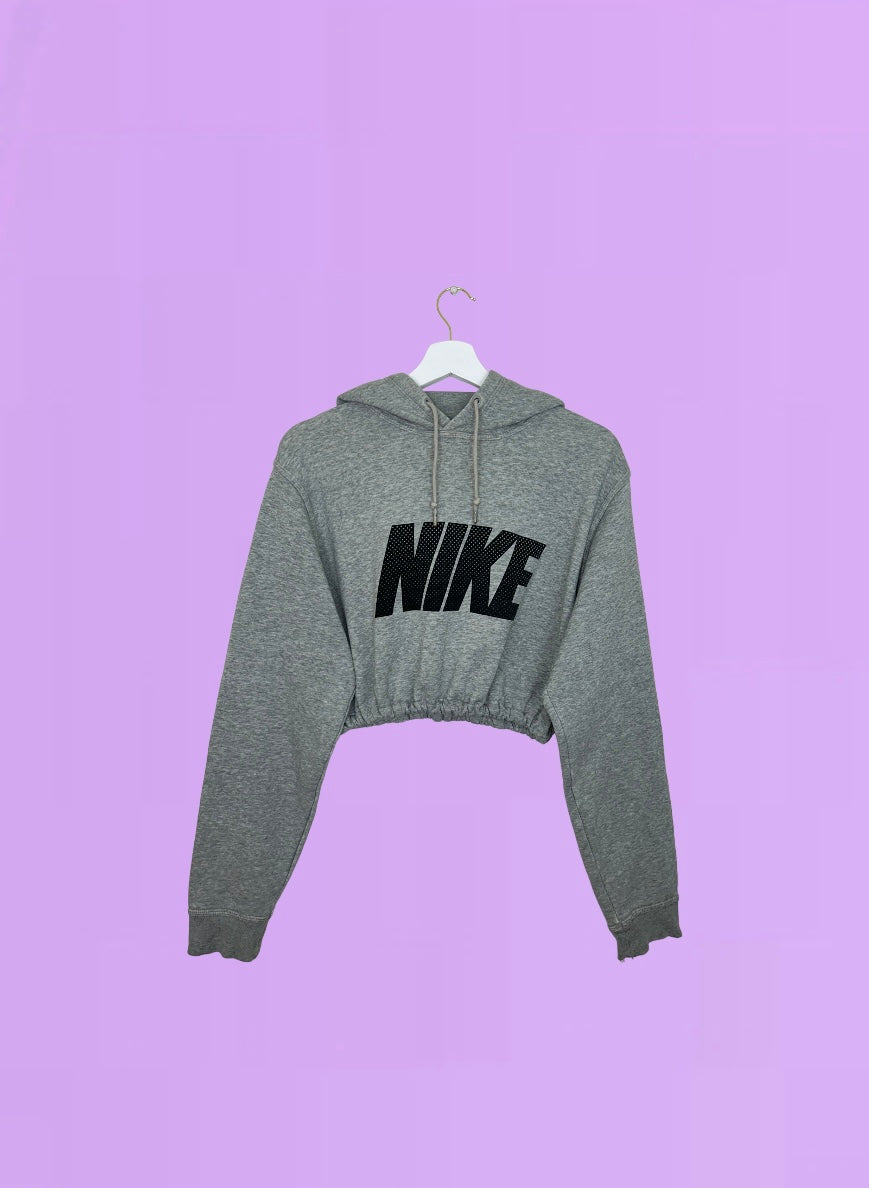 grey cropped hoodie with black nike logo shown on a lilac background