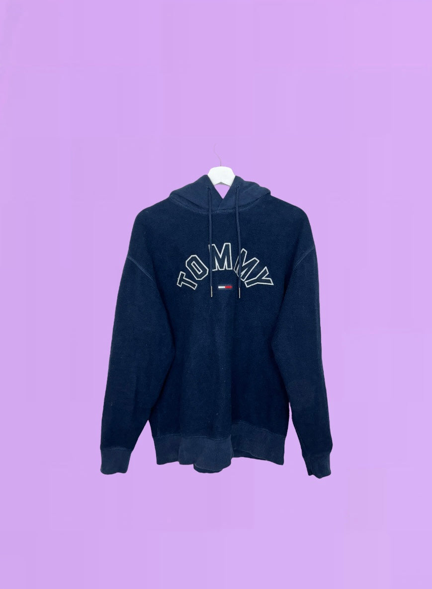 navy blue fleece hoodie with white tommy logo shown on a lilac background