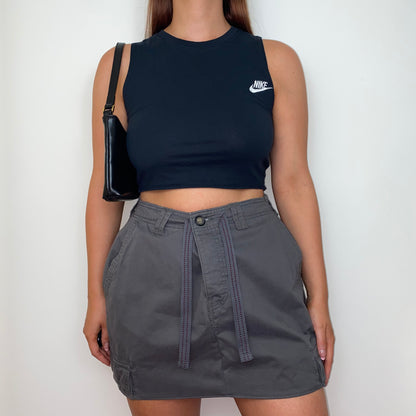 grey mini cargo skirt shown on a model wearing a black crop top and black shoulder bag