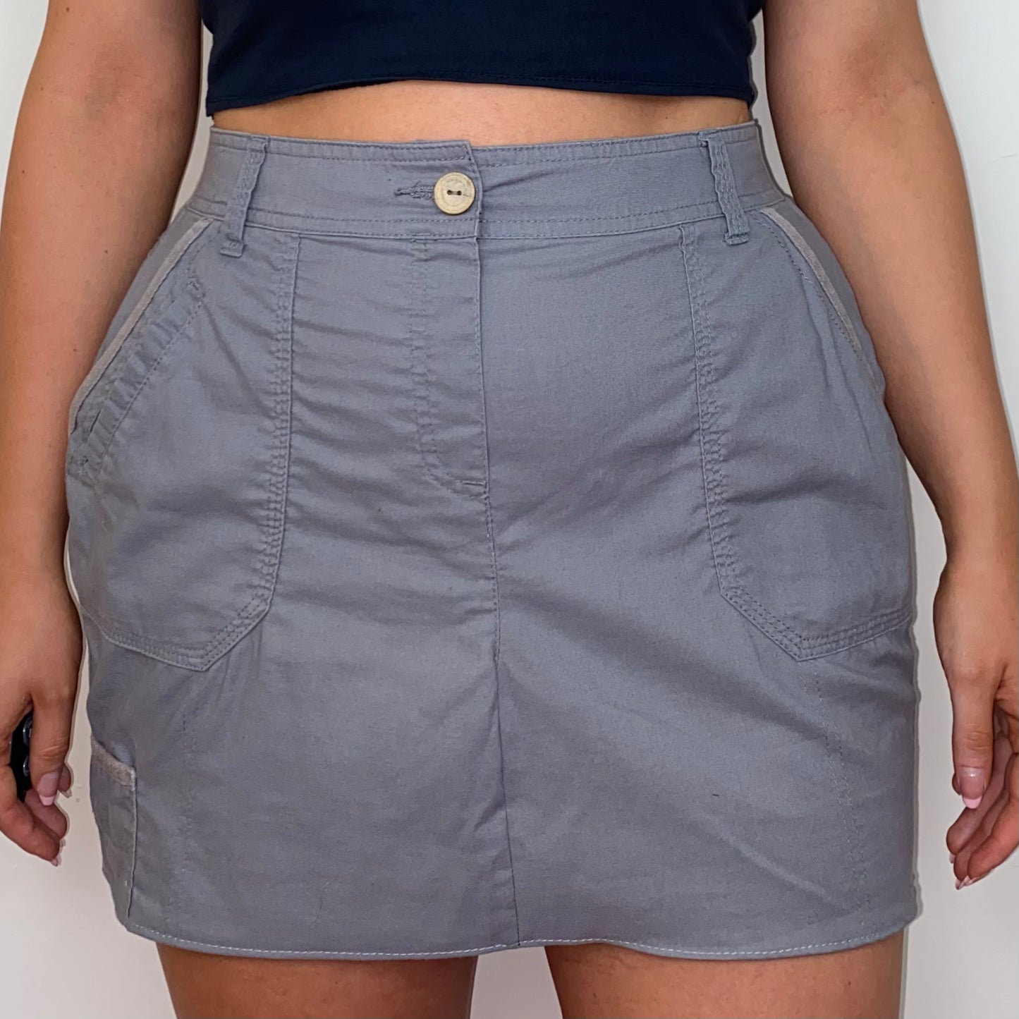 close up of a grey mini cargo skirt shown on a model