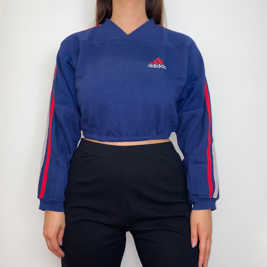 navy cropped sweatshirt with red adidas logo shown on a model wearing black trousers