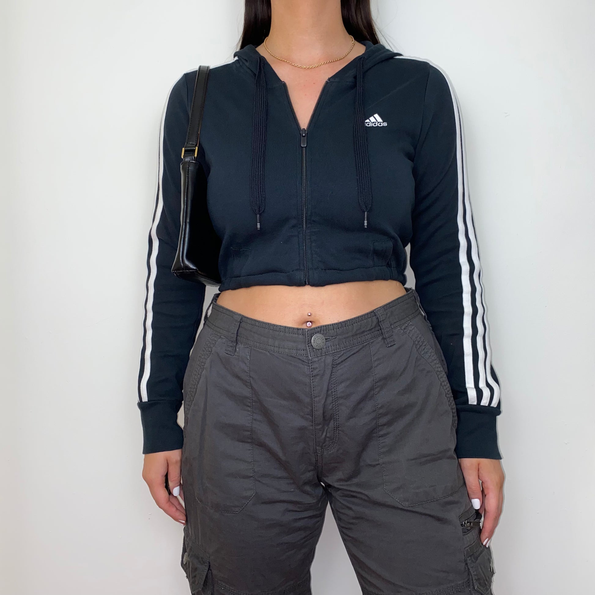 black 1/4 zip cropped hoodie shown on a model wearing grey cargo trousers and a black shoulder bag