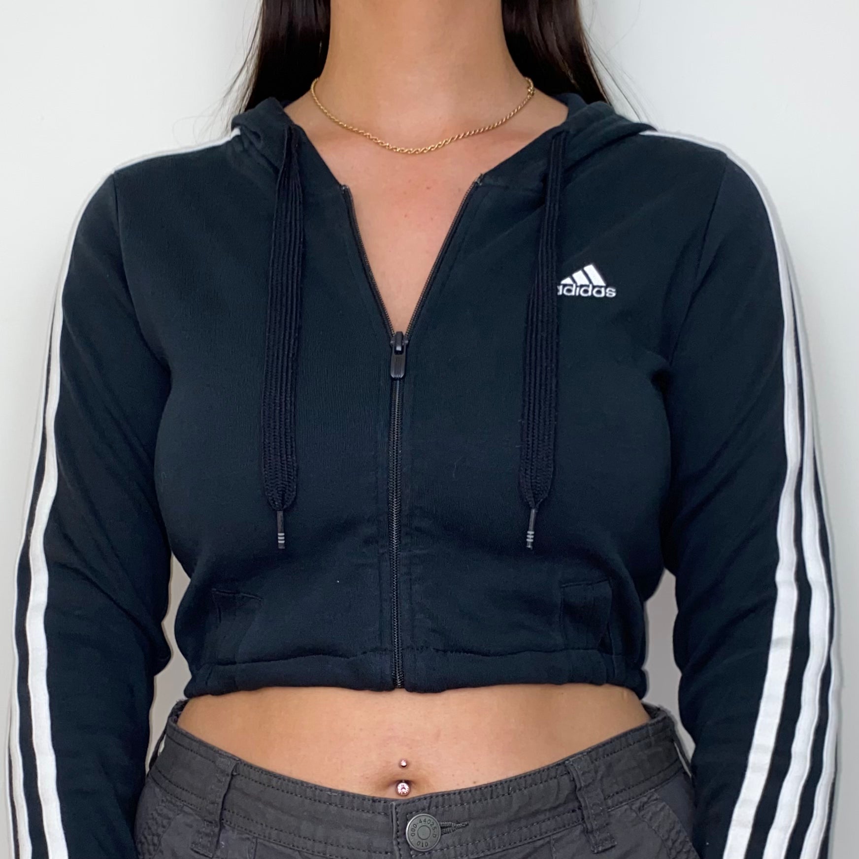 close up of a black 1/4 zip cropped hoodie shown on a model wearing grey cargo trousers