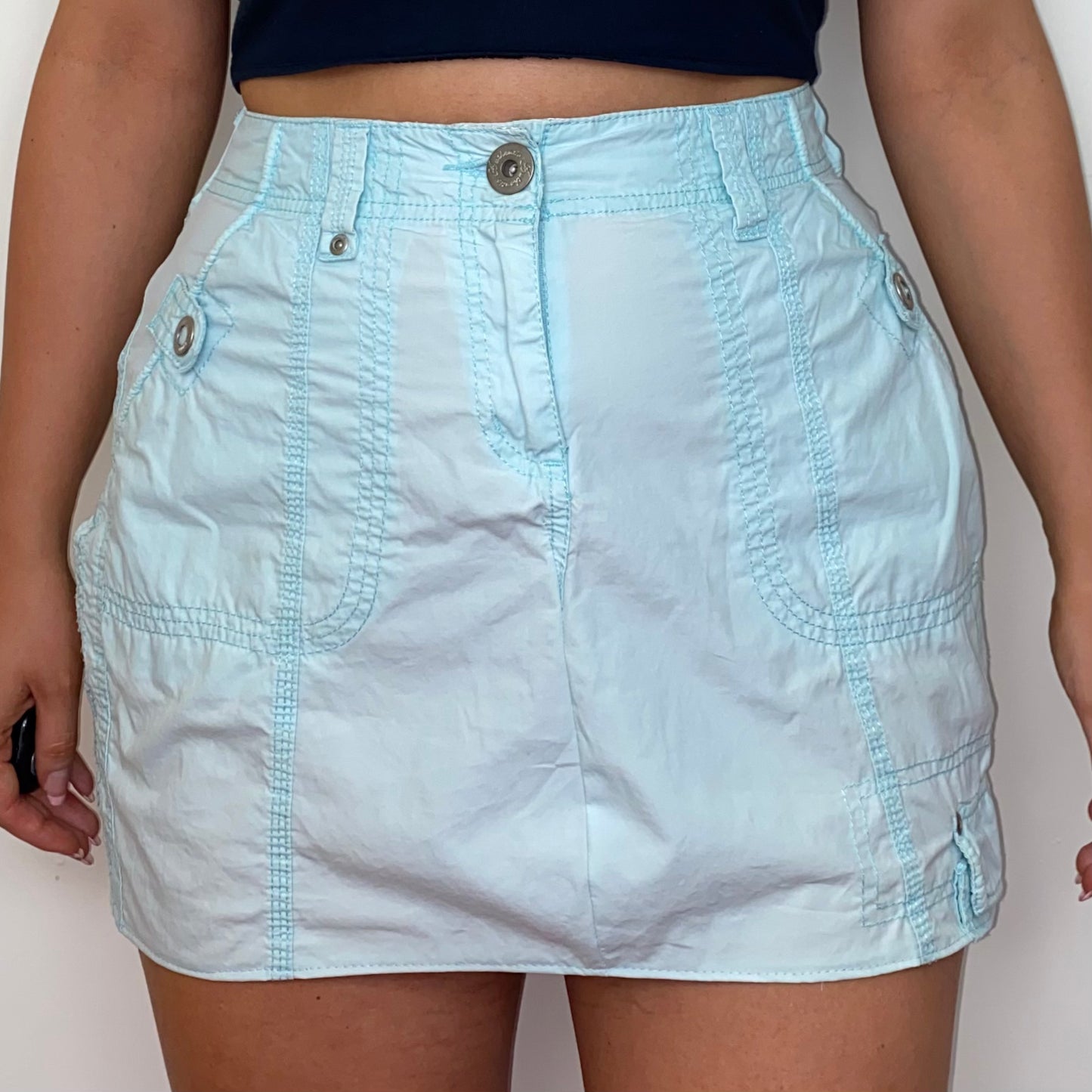 close up of a light blue mini cargo skirt shown on a model
